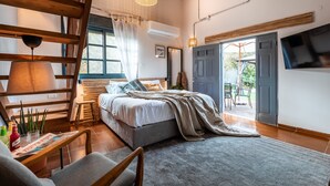 A spacious bedroom with a large bed, a wooden ceiling, a ceiling fan, and a view of the outdoors. - Dolphin Village - Sea Resort (Mateh Asher)