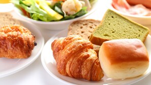 A plate with croissants, bread, and a sandwich. - Hotel Hokke Club Osaka (Osaka)