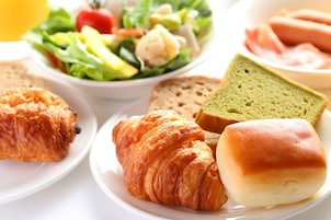 Une assiette avec des croissants, du pain et un sandwich.