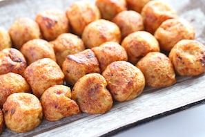 Un plateau rempli de viennoiseries rondes, dorées et cuites au four.