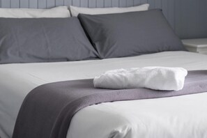 Restful retreat with a neatly made bed and a gray throw blanket.