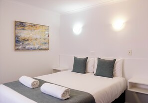 A hotel room with a bed, two pillows, a painting on the wall, and a nightstand. - Central Motel Port Fairy (Port Fairy)