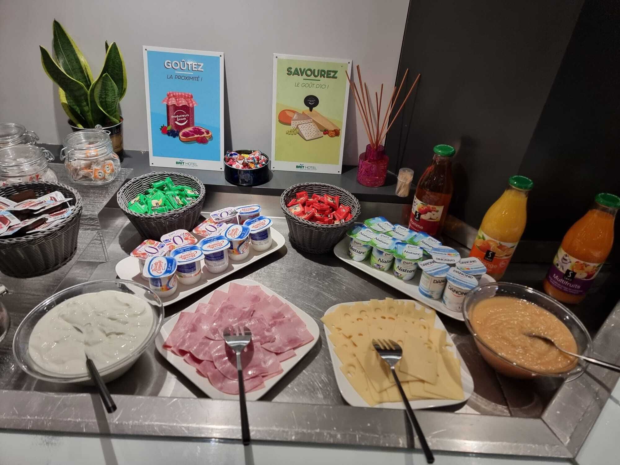 A buffet with various food items including yogurt, cheese, and fruit juices.