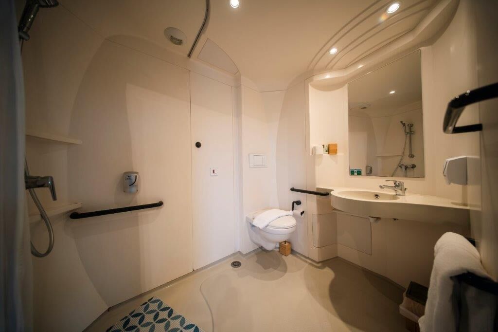 Ein modernes Badezimmer mit Toilette, Waschbecken und Dusche.