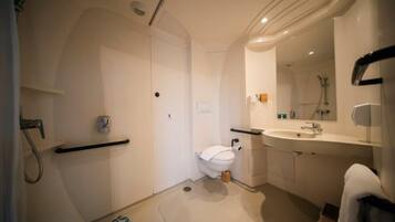 Ein modernes Badezimmer mit Toilette, Waschbecken und Dusche.