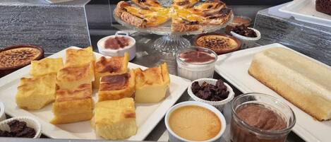 Un bufé con diversos postres, como pasteles, cremas y repostería.