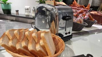 Un grille-pain avec un panier de tranches de pain devant.