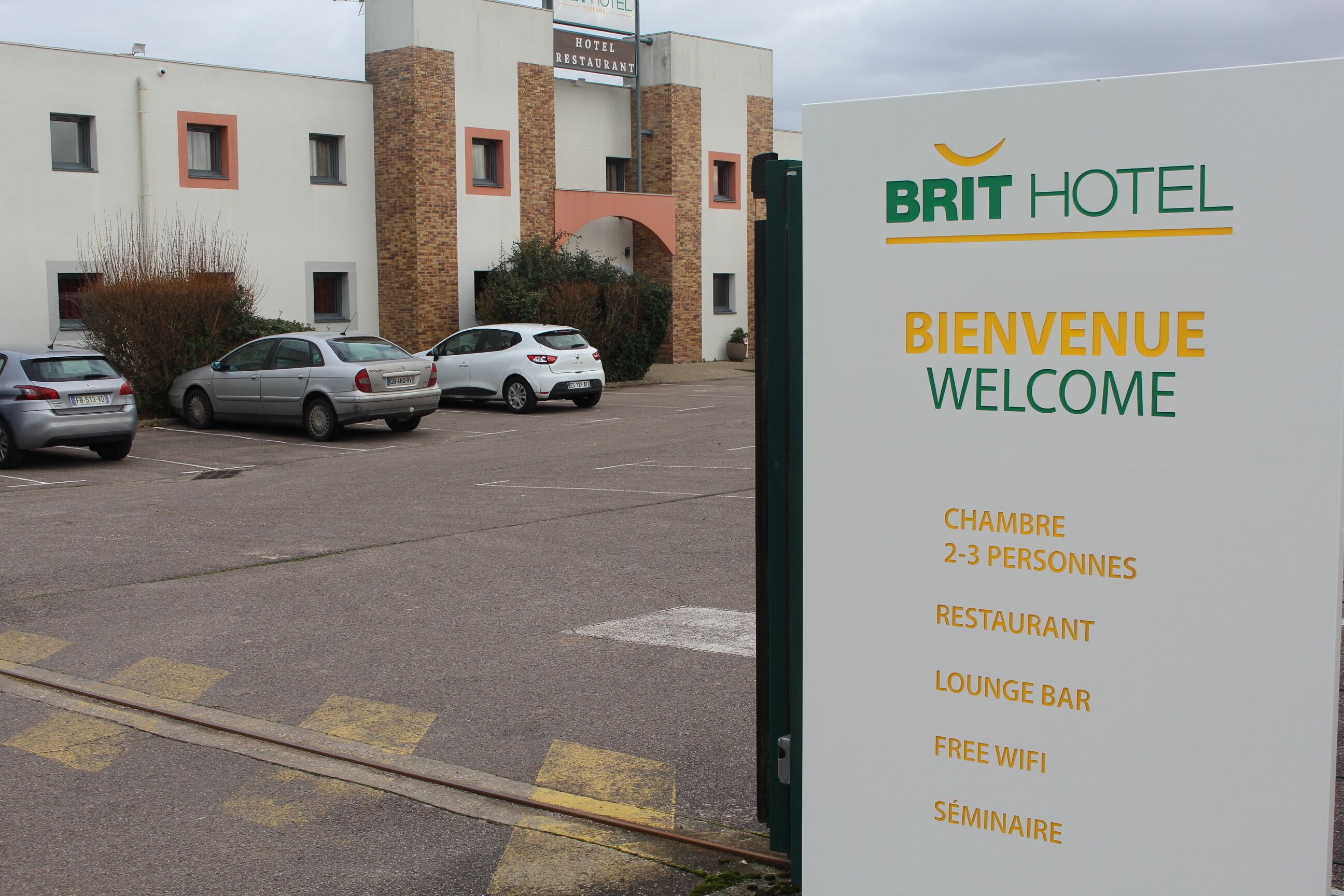 Señal de Brit Hotel con servicios que incluyen restaurante, bar salón, wifi gratuito y sala de seminarios.
