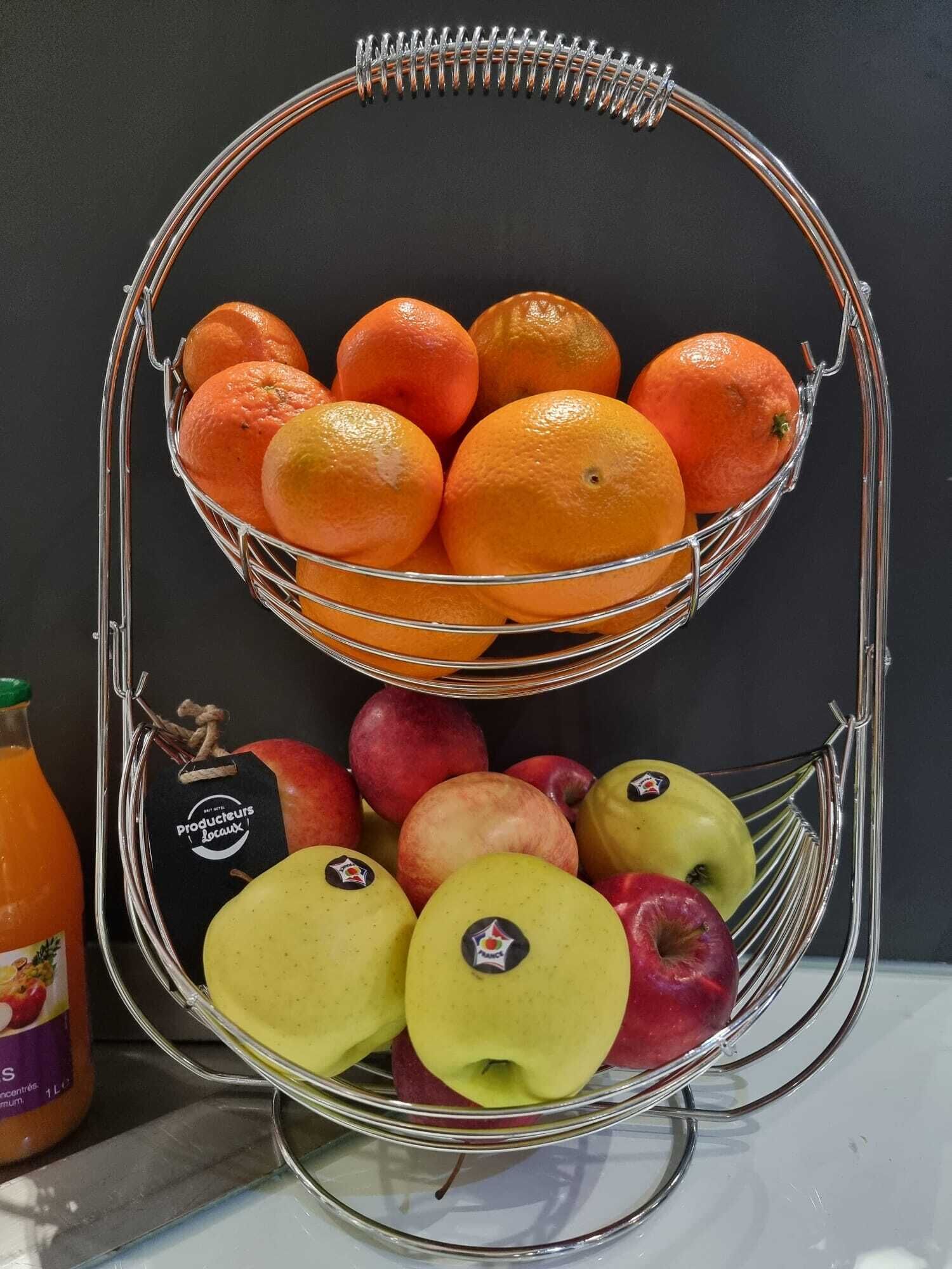 A metal fruit stand with oranges and apples.