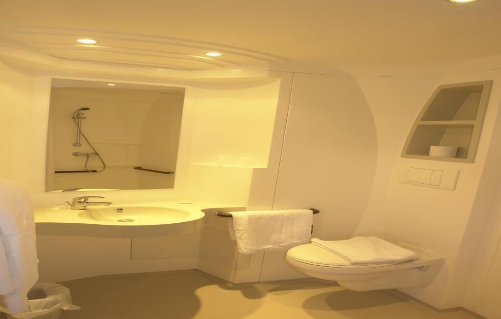 Ein modernes Badezimmer mit Waschbecken, Spiegel und Toilette.