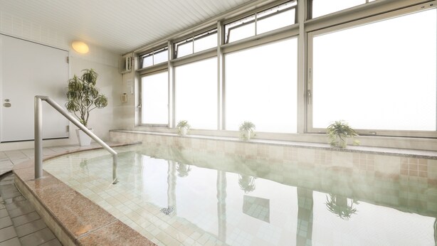 An indoor swimming pool with clear glass walls, a tiled floor, and a metal handrail. - Hotel Famy Inn Kinshicho (Tokyo)