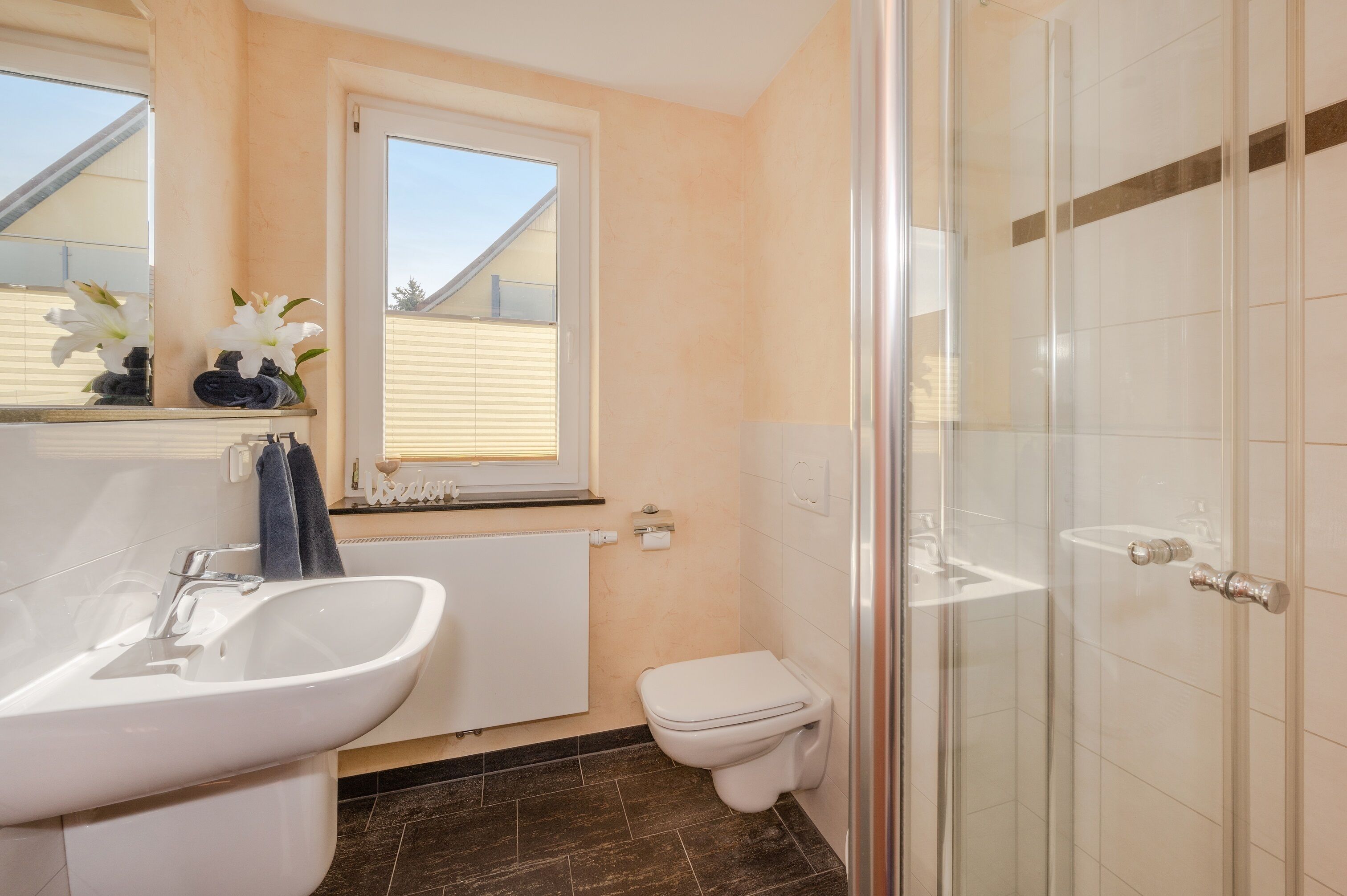 A bathroom with a sink, toilet, and glass shower enclosure.