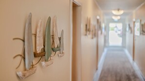 A hallway with wooden wall art and a wooden floor. - Inselhof Vineta (Zempin)