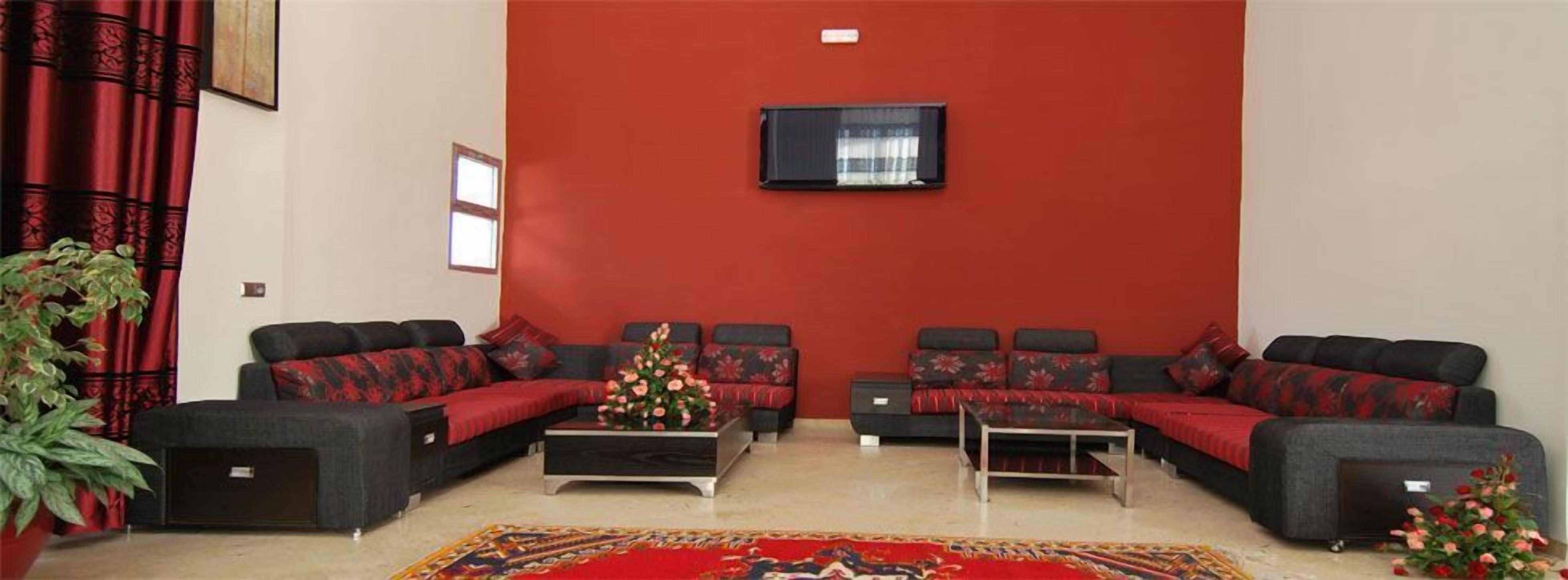 Una sala de estar con dos sofás, una mesa de centro y un televisor montado en la pared.