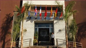 The entrance to the hotel with a sign reading "HOTEL COUNTY" and multiple flags. - Appart Hotel Founty Beach (Agadir)