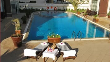 Una piscina al aire libre, tumbonas