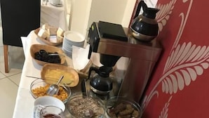 Ein reichhaltiges Buffet mit verschiedenen Speisen, darunter Obst, Gebäck und Getränke.