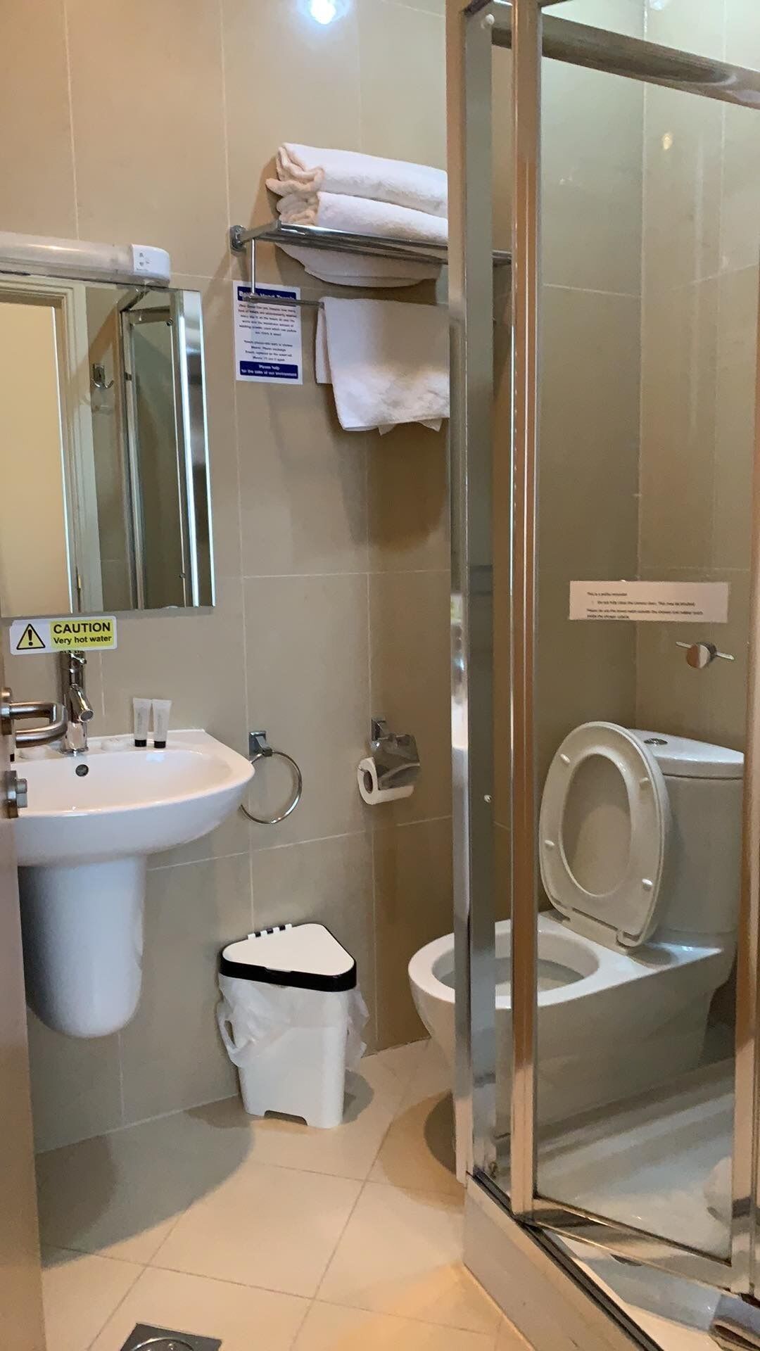 A bathroom with a sink, toilet, and glass shower enclosure.