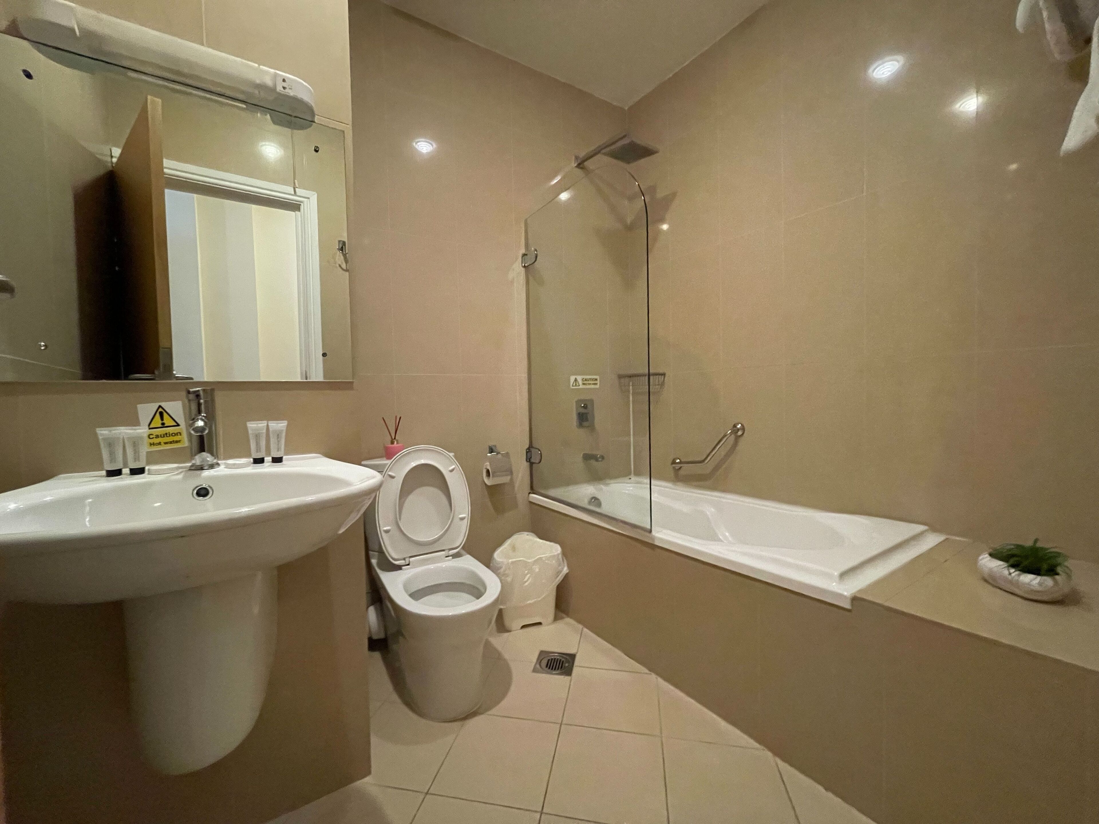 A modern bathroom with a sink, toilet, and bathtub.