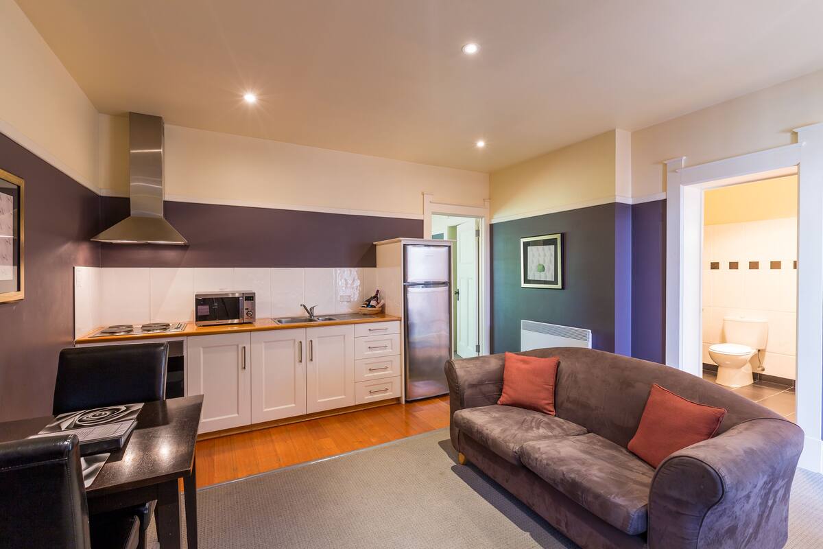 A compact living space with a kitchenette, dining area, and a sofa.