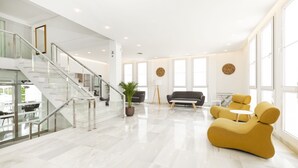 Un interior amplio y moderno con una escalera, un sofá y una zona de comedor.