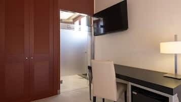 Una habitación con escritorio, silla, televisor y lámpara.