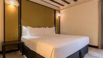 Ein Hotelzimmer mit einem großen Bett, einem Nachttisch und zwei Wandlampen.