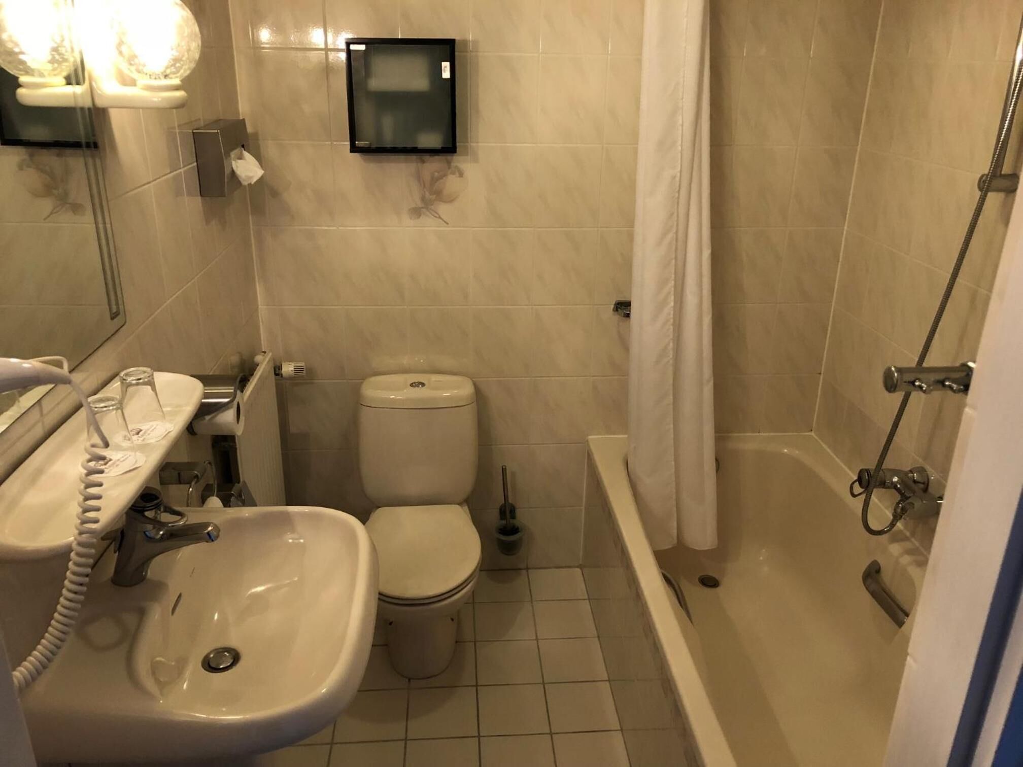 A bathroom with a sink, toilet, and bathtub.