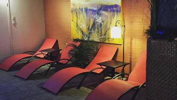 A spa area with reclining chairs, a wall-mounted lamp, and a painting.