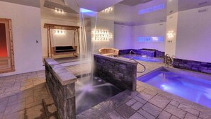 Un espacio de spa con un jacuzzi, una cascada y una silla de masajes.