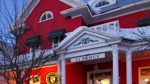 Un edificio rojo con entrada blanca y un letrero que dice "AUBERGE".