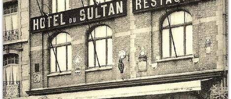 Un edificio con letreros que indican 'Hotel du Sultan' y 'Restaurante'.