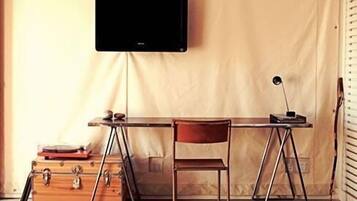 A compact workspace with a desk, chair, and a mounted television.