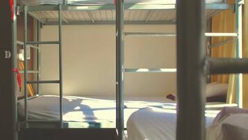 Habitación con literas, una escalera metálica y una cama individual.
