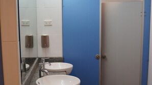Une salle de bain avec deux lavabos, un miroir et une porte bleue.