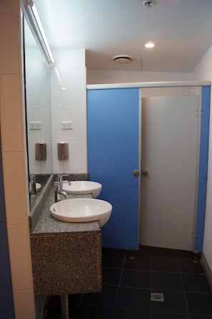 A bathroom with two sinks, a mirror, and a blue door. - 790 on George Backpackers (Haymarket)