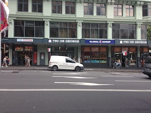 A street view with a white van parked in front of a building with multiple storefronts, including '790 on George' and 'Global Gossip'. - 790 on George Backpackers (Haymarket)