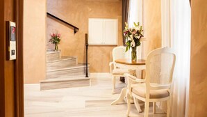 A hotel room with a marble staircase, a dining area with wicker chairs, and a white cabinet. - Meroddi Pera Flats (Istanbul)