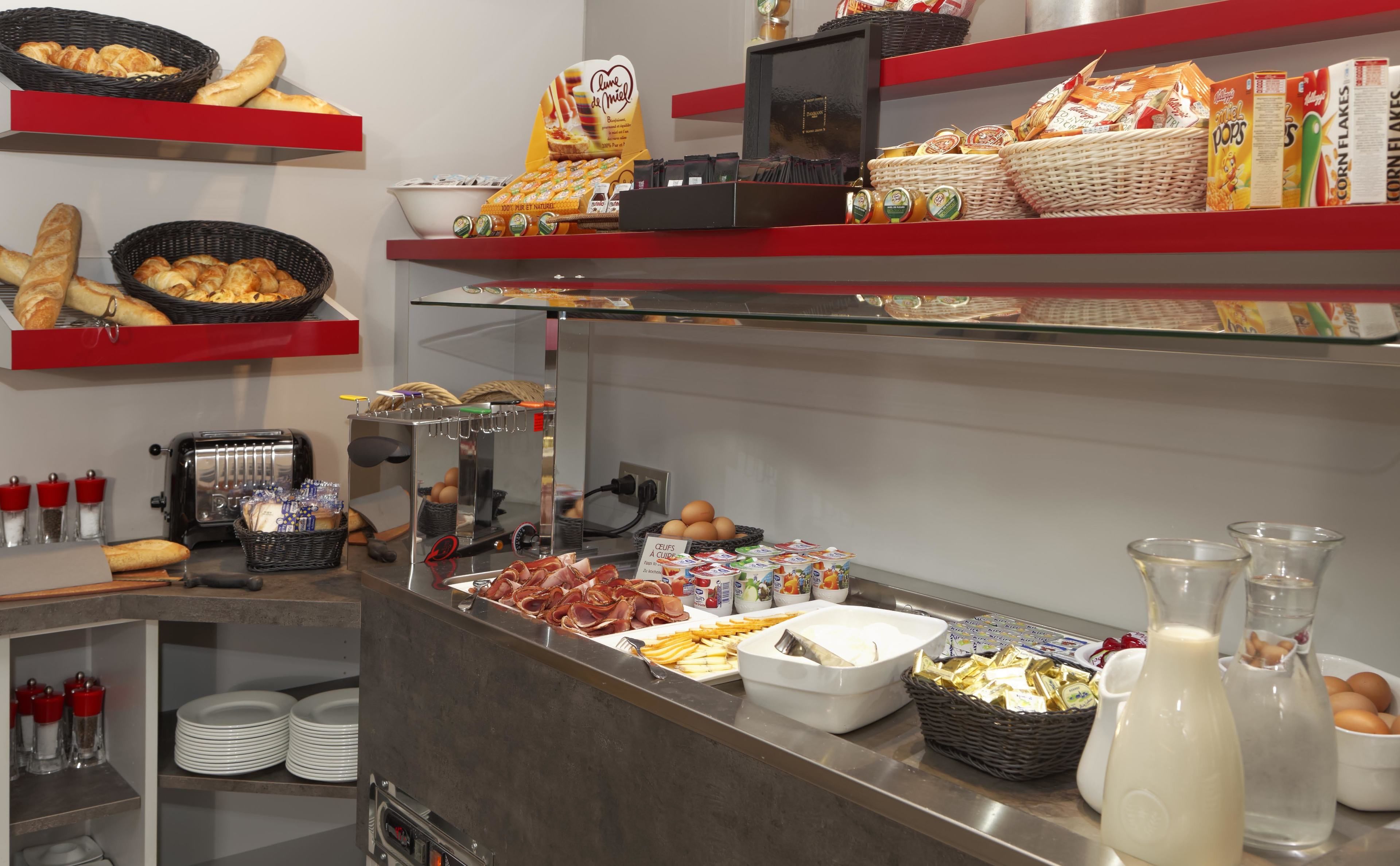 A buffet setup with various food items, including bread, pastries, and condiments.
