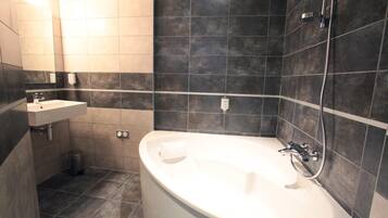 A modern bathroom with a freestanding bathtub, a sink, and a mirror.