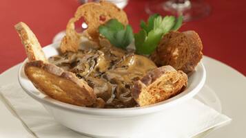 Una ciotola di zuppa di funghi con del pane a fianco.