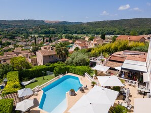 A pool area with a clear view of the surrounding landscape, including houses and hills.