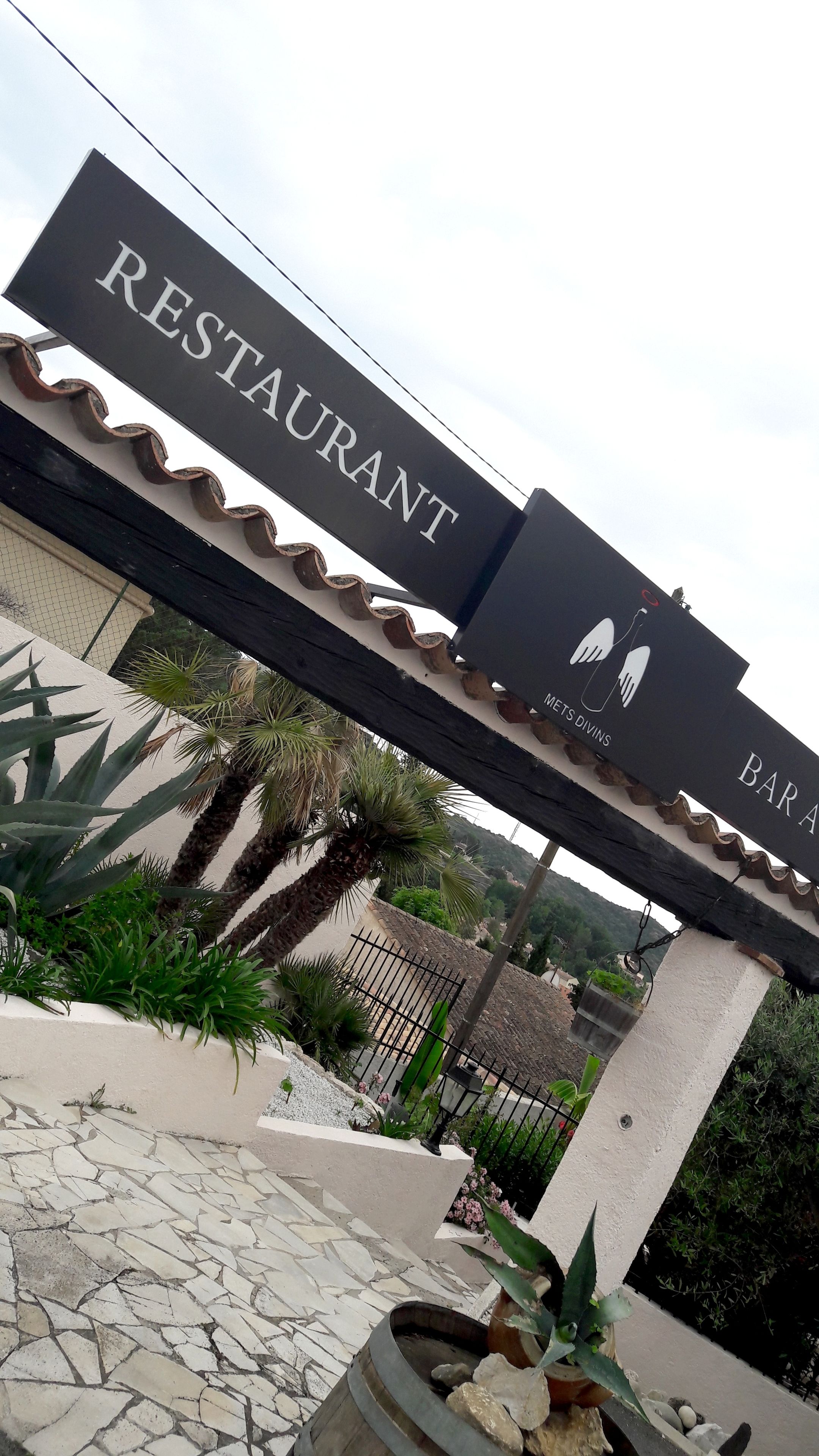 A restaurant sign with a wavy top and the word "RESTAURANT" in large letters.