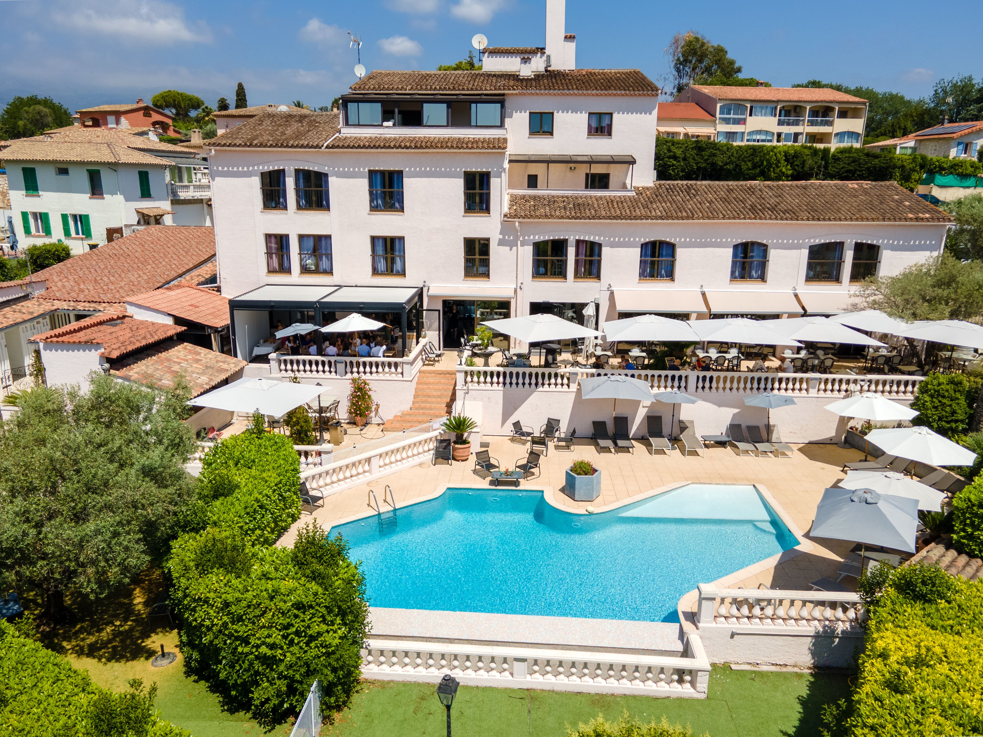 Um edifício grande com piscina, área de estar ao ar livre e gramado bem cuidado.