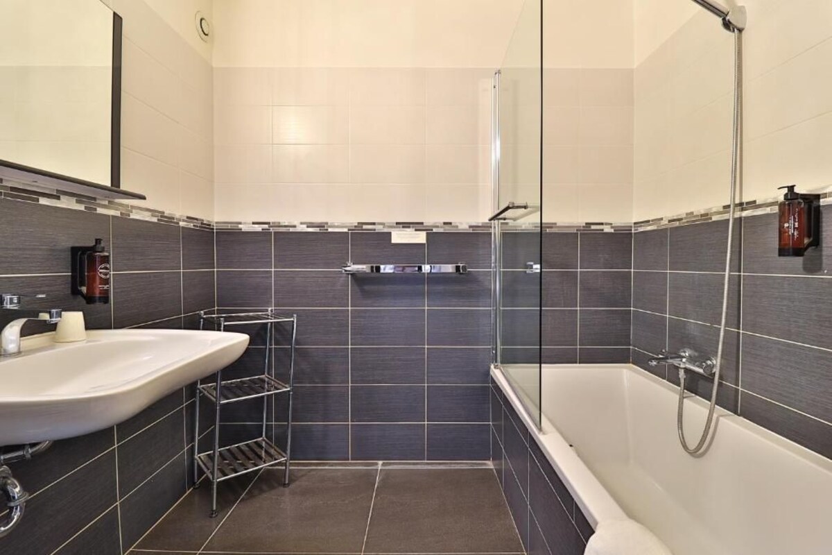 Un baño moderno con bañera, lavamanos y ducha.