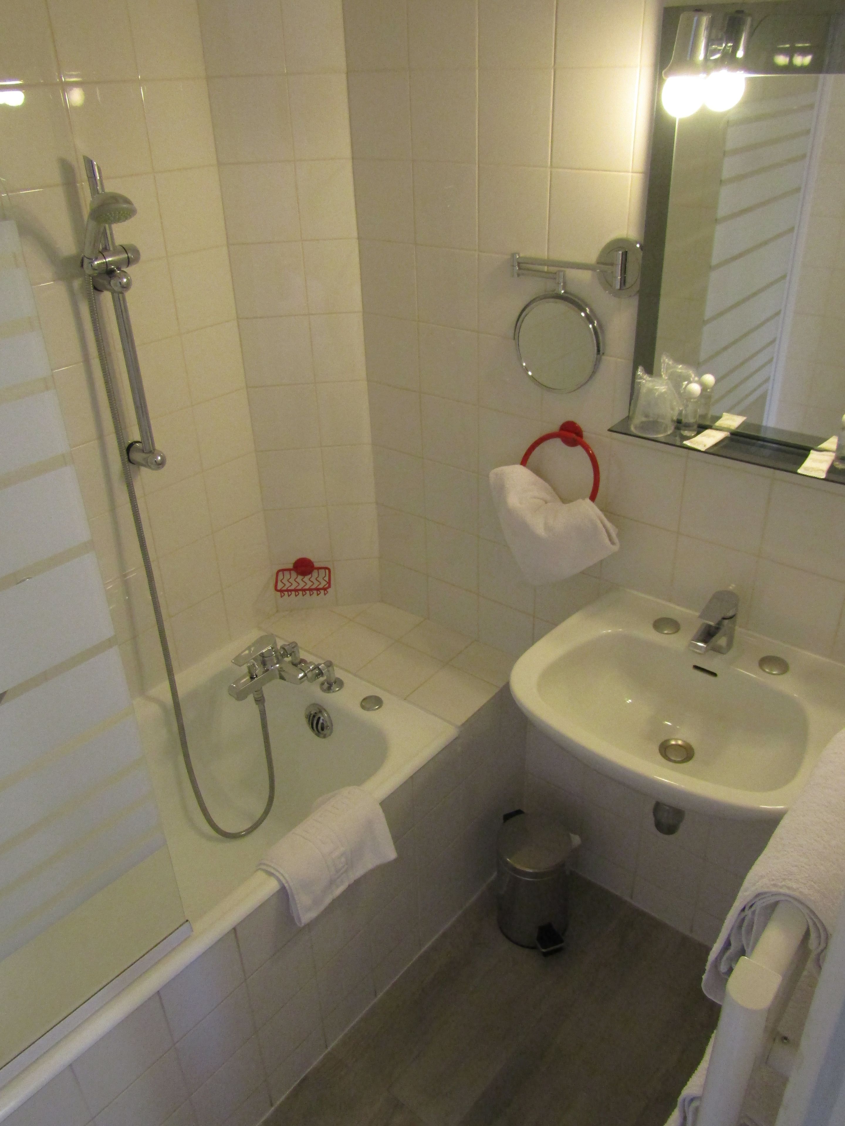 A bathroom with a bathtub, a sink, and a mirror.