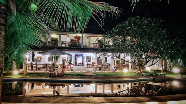 A two-story building with outdoor seating and a pool. - Kenyan House Malindi (Malindi)