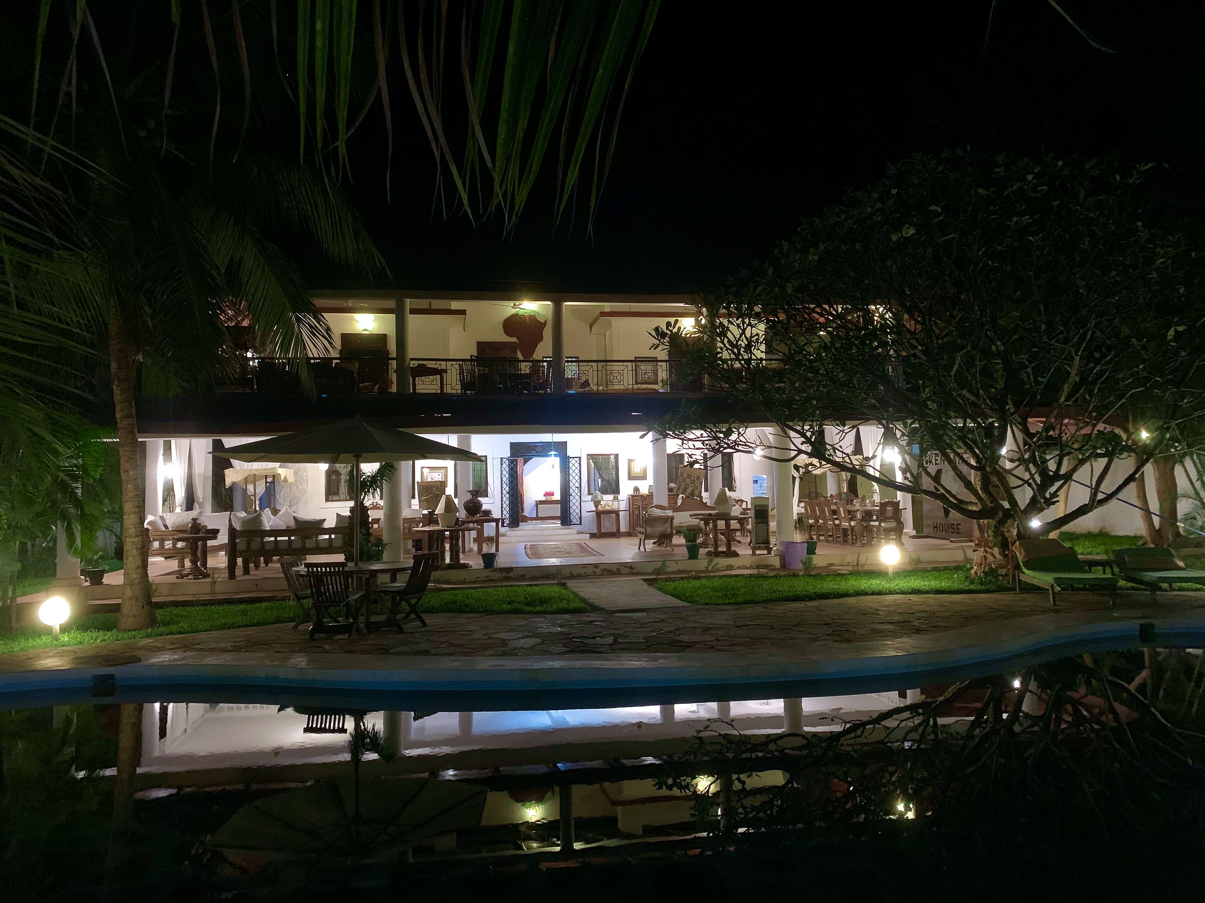 A two-story building with outdoor seating and a pool.