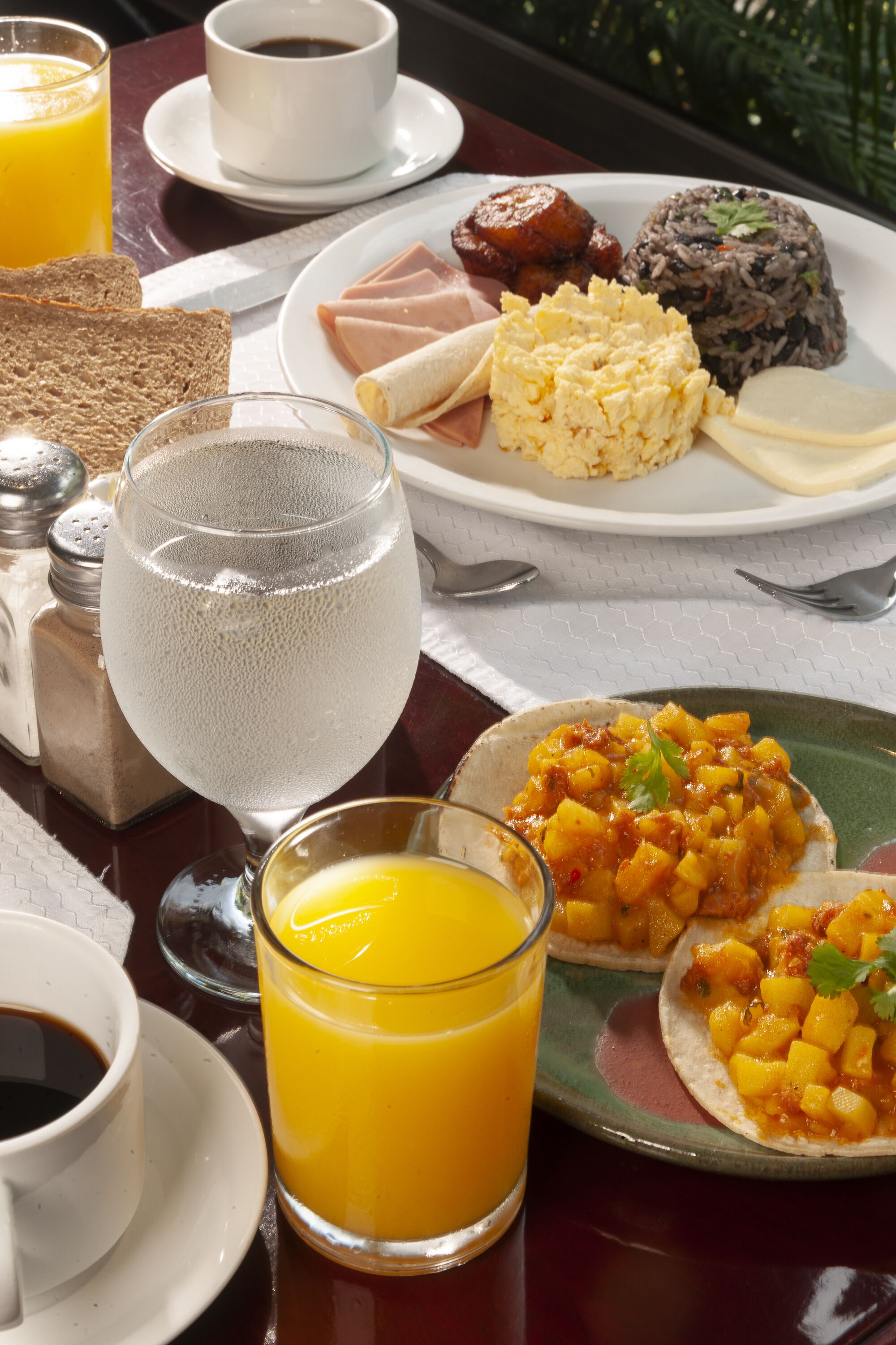 A breakfast setting with a plate of food, a glass of orange juice, and a cup of coffee.