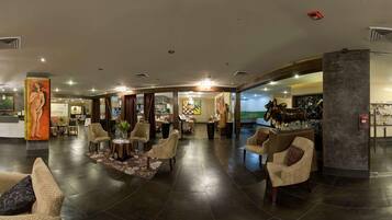 A spacious lobby with a reception desk, comfortable seating areas, and a large decorative sculpture.